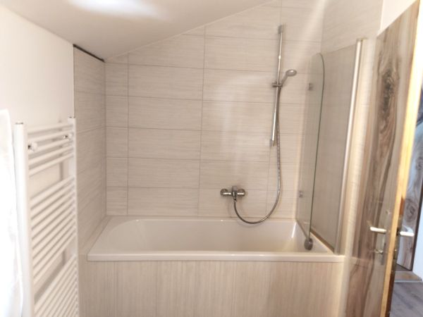 Großzügiges Badezimmer mit Badewanne und Dusche